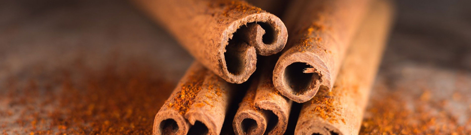 Shows an image of cinnamon sticks on a bed of cinnamon powder