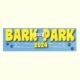 Shows the words Bark in the Park 2024 in yellow on a blue background with two sets of doggie prints